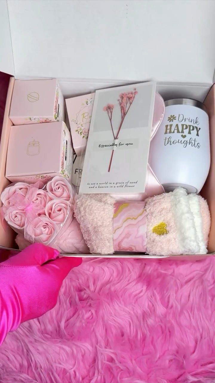 Self care gift box with pink roses, a tumbler, and fluffy towels on pink fur.