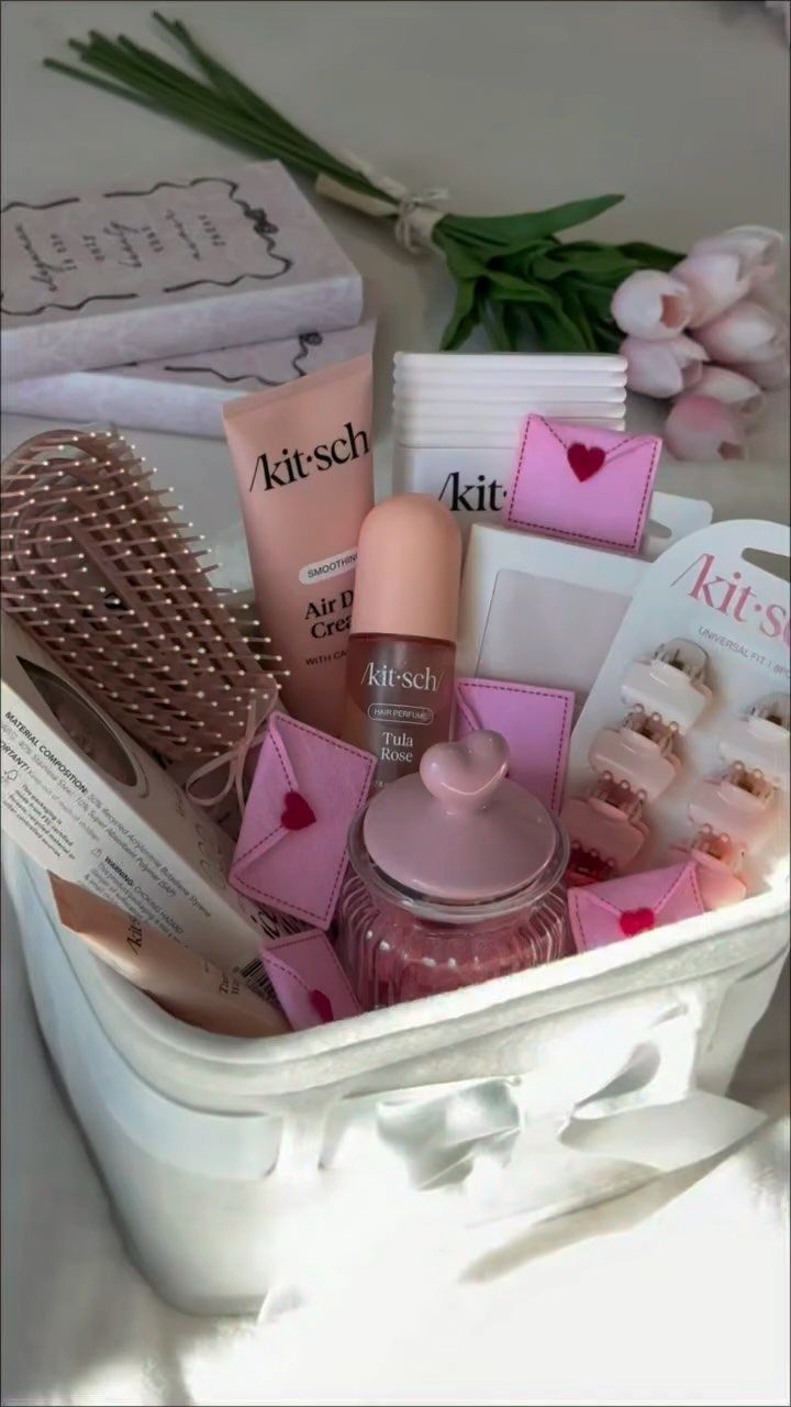 White basket filled with pink beauty products, skincare, and small decorative envelopes.