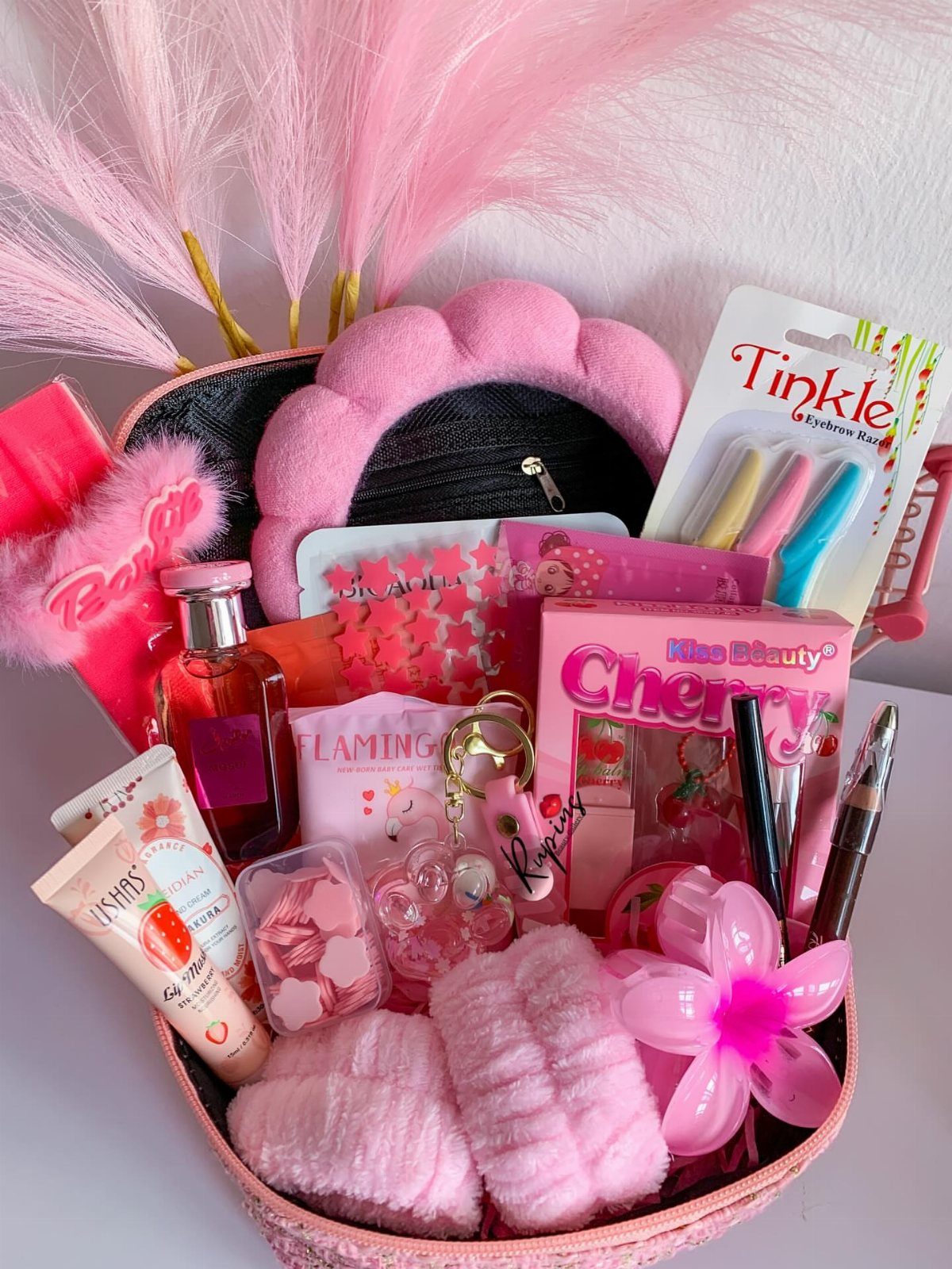 Pink self care basket filled with beauty products, plush headband, and skincare items.