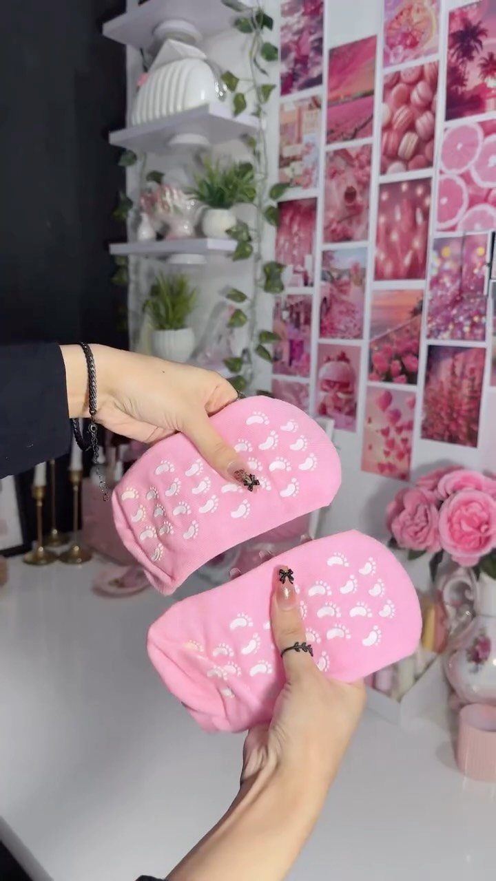 Pink fluffy socks held by hands against a pink aesthetic room background