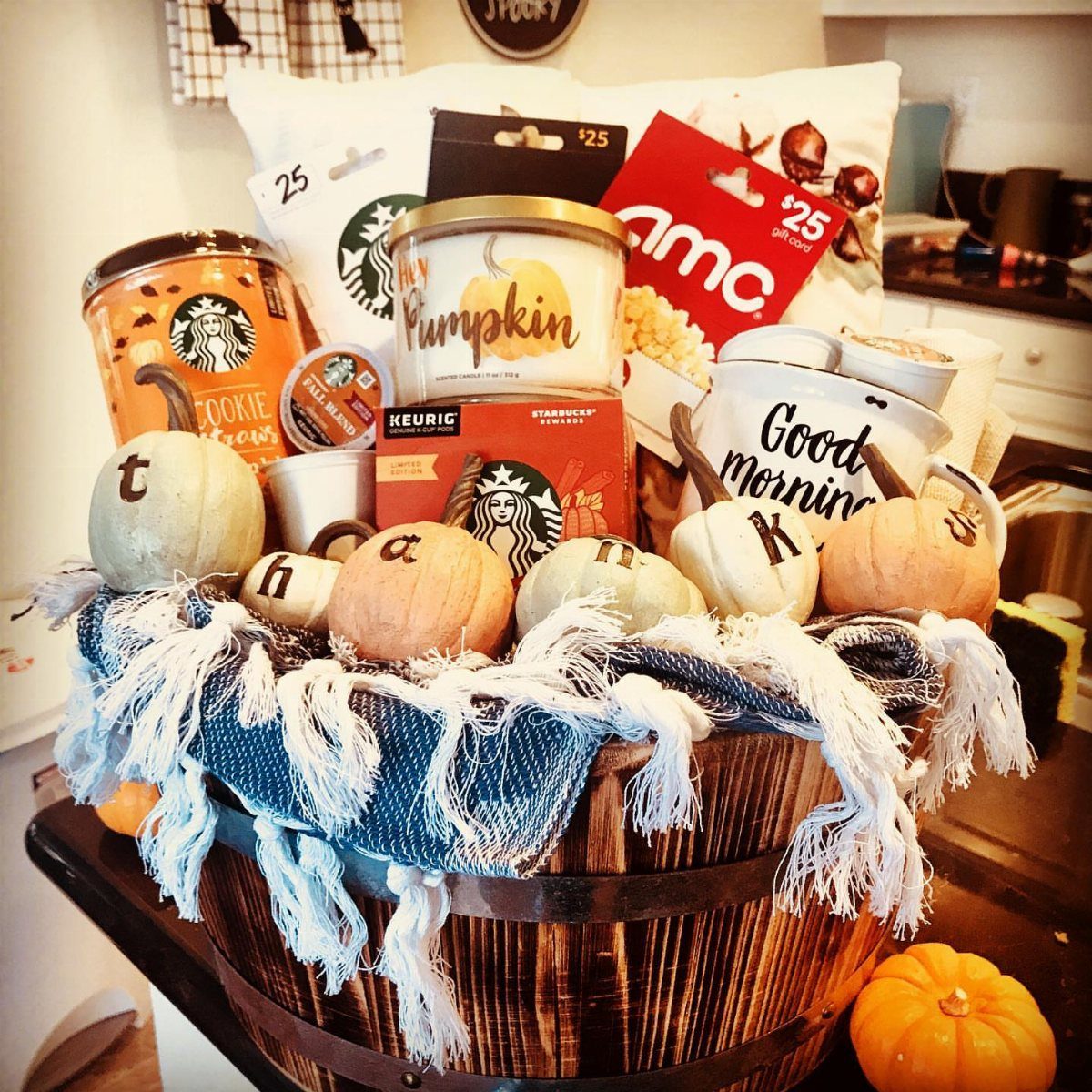 Autumn-themed silent auction basket in a wooden barrel with coffee and pumpkins.
