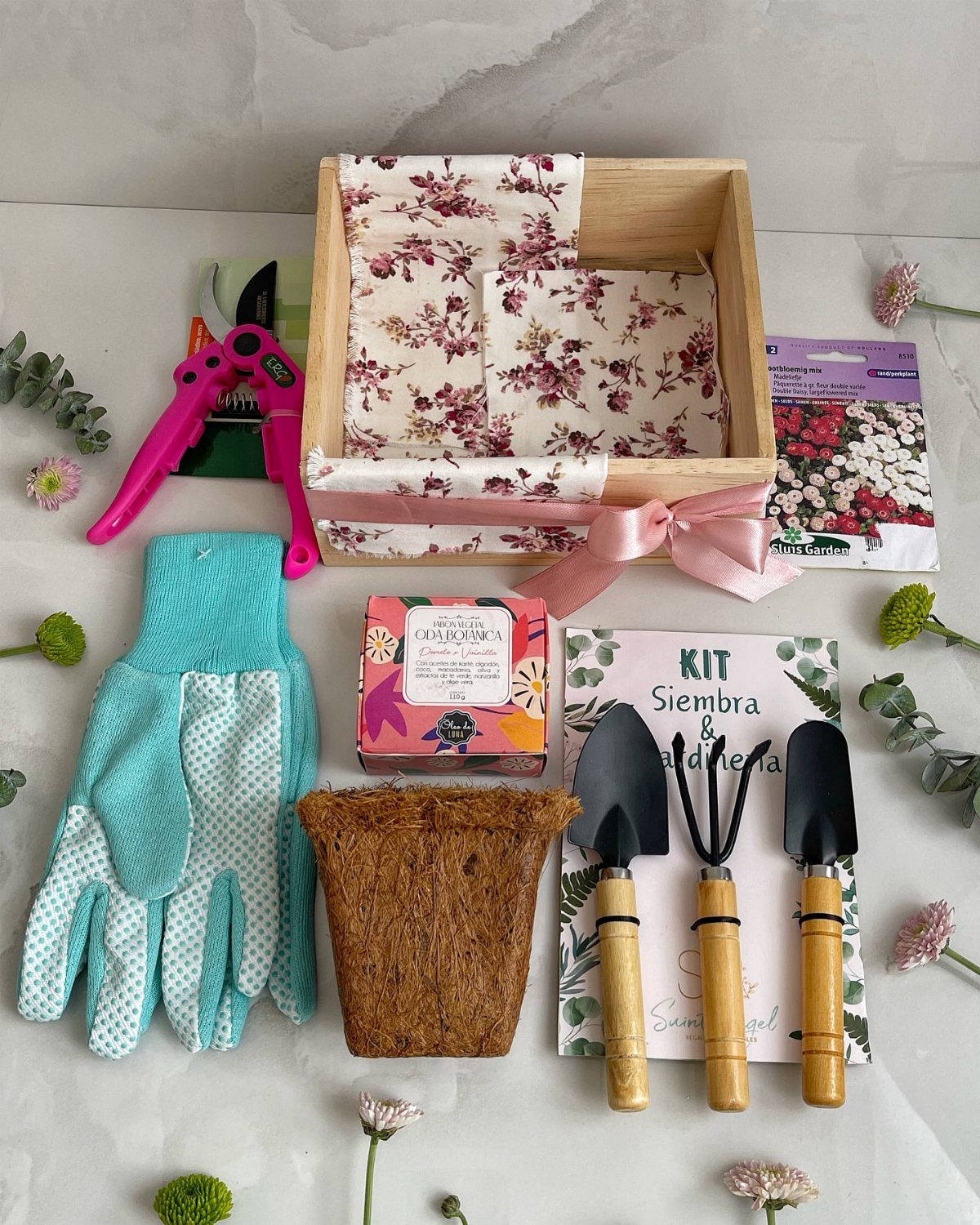 Gardening starter kit with tools, gloves, and seeds arranged around a wooden crate.
