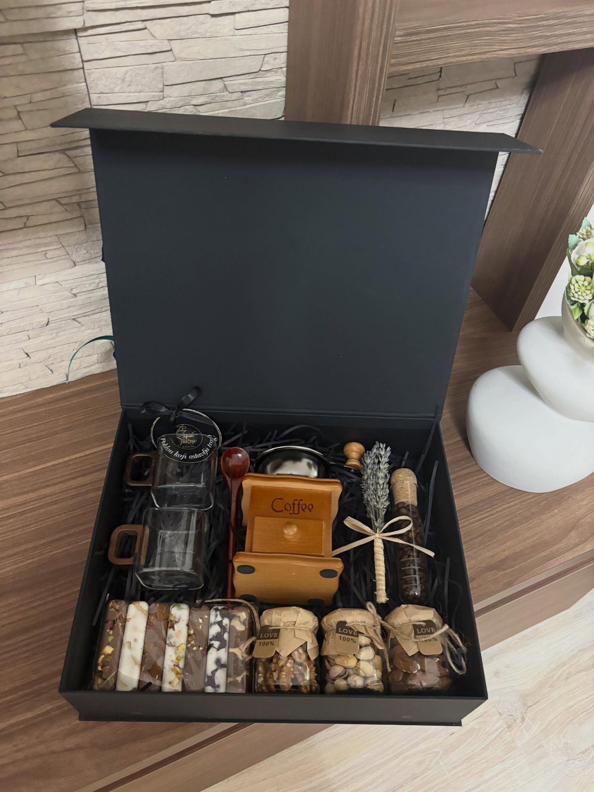 Coffee gift set in a black box with mugs, wooden accessories, and treats.