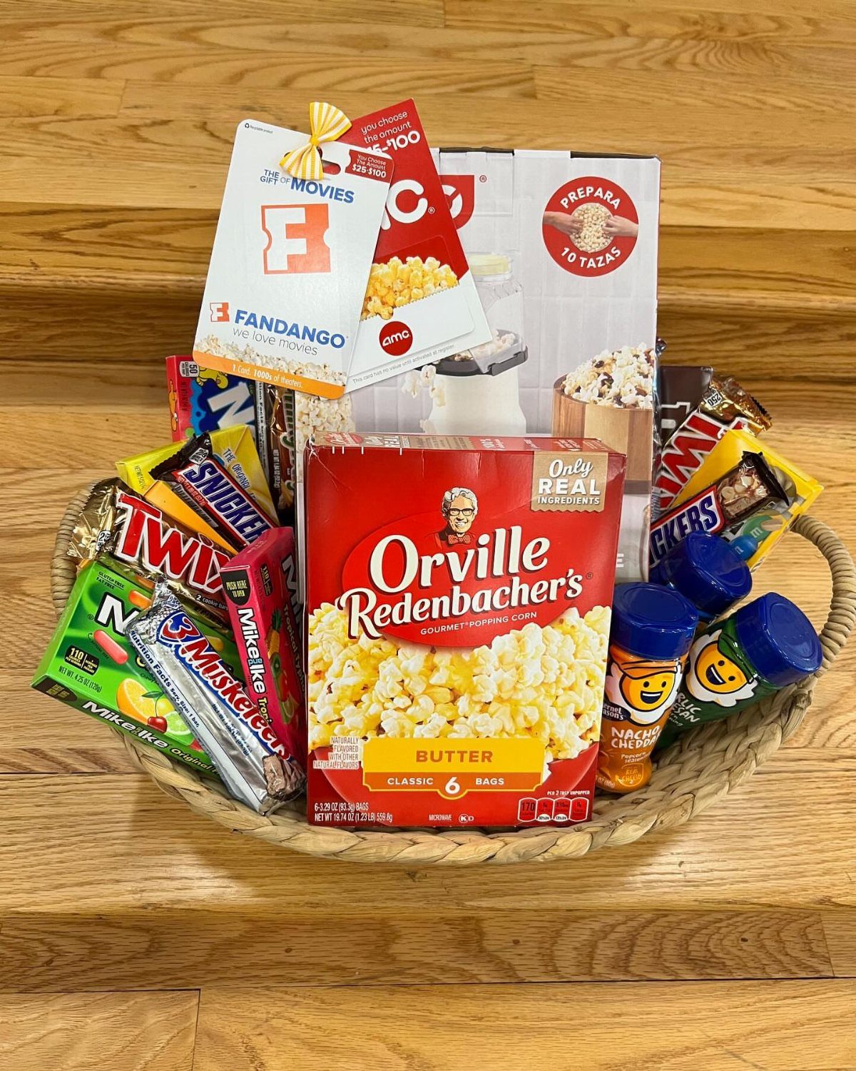 Movie night gift basket with popcorn, assorted candy bars, and a movie ticket card.