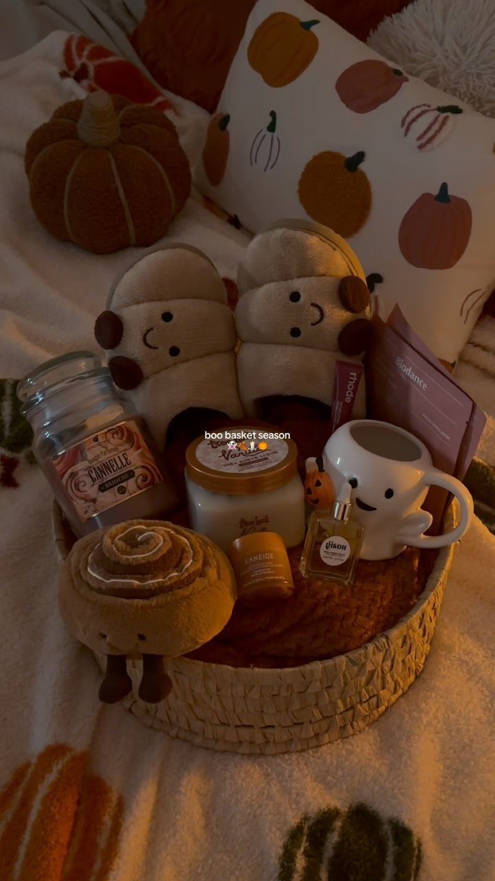 Woven gift basket with skincare cream, perfume, slippers, and a smiley mug.