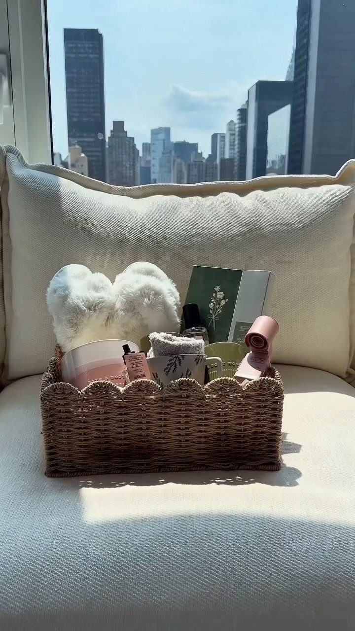 Woven wicker basket filled with skincare products and towels against a city skyline.