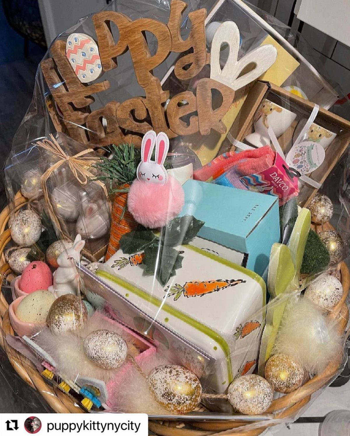 Easter gift basket with gold eggs, bunny figurine, and Happy Easter wooden sign.
