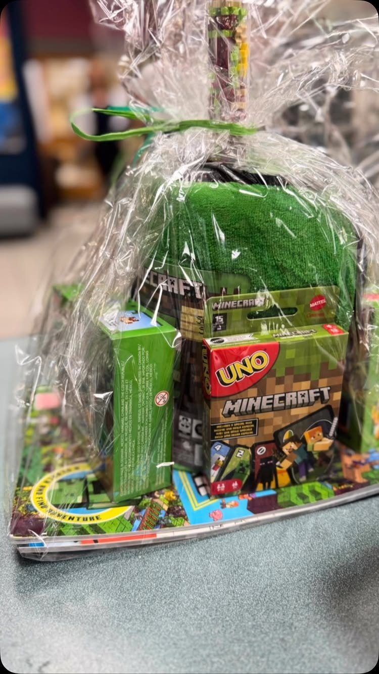 Minecraft themed gift basket wrapped in cellophane with green toys and UNO cards.