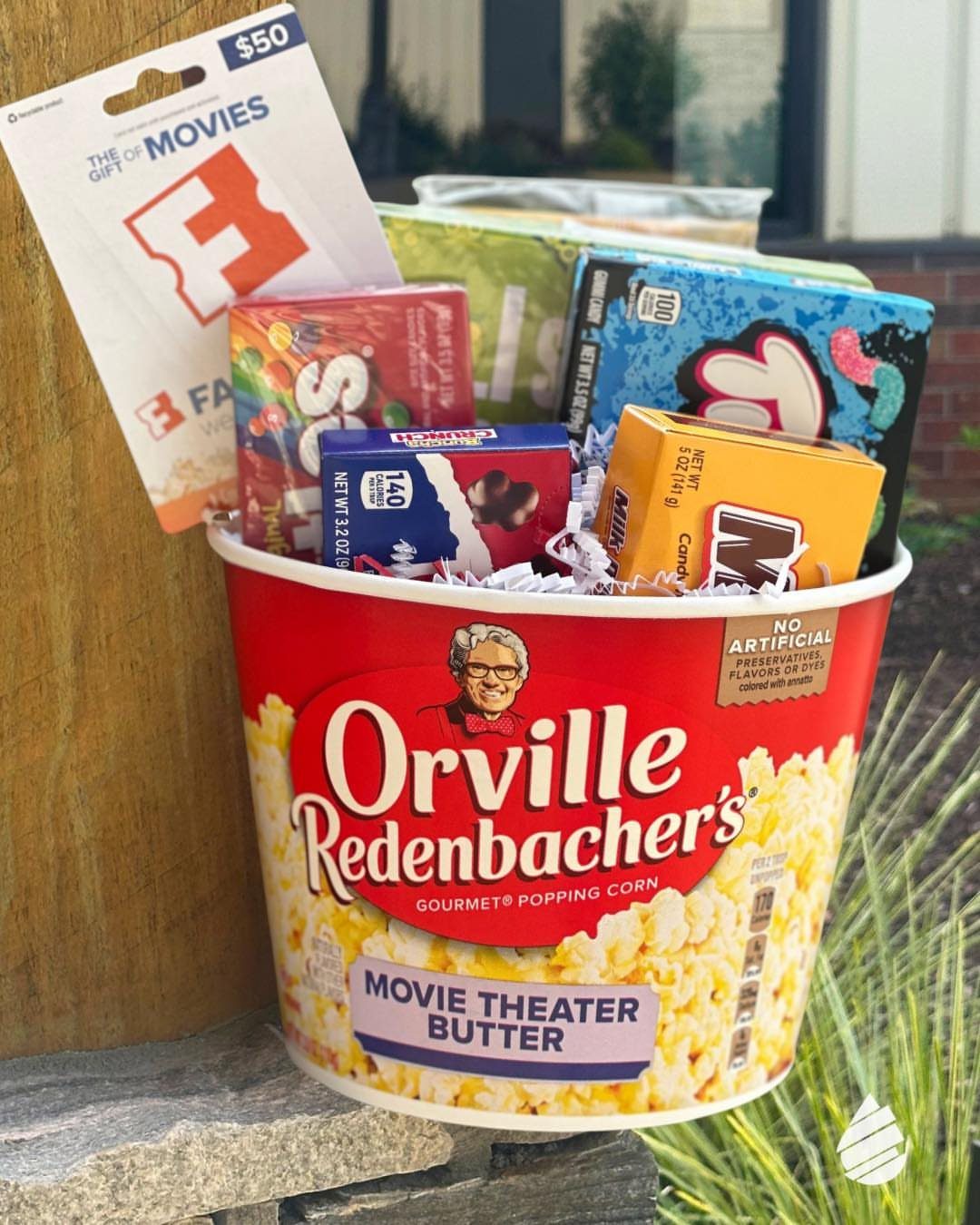 Popcorn bucket filled with movie theater candy and a gift card for movie night.
