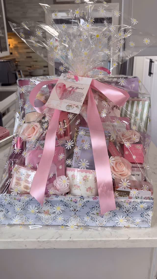 Self-care gift basket with pink beauty products and roses wrapped in cellophane.