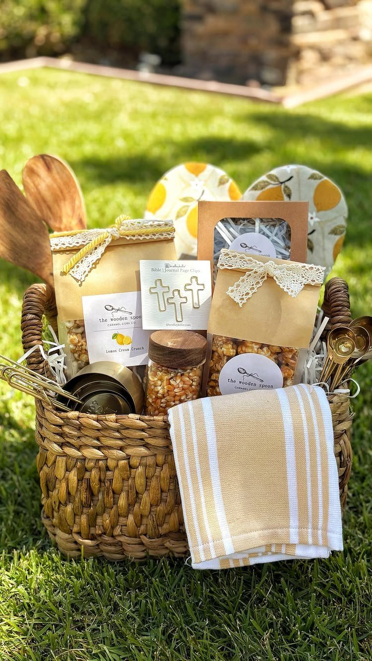 Woven gift basket with lemon themed items and gourmet treats on green grass.