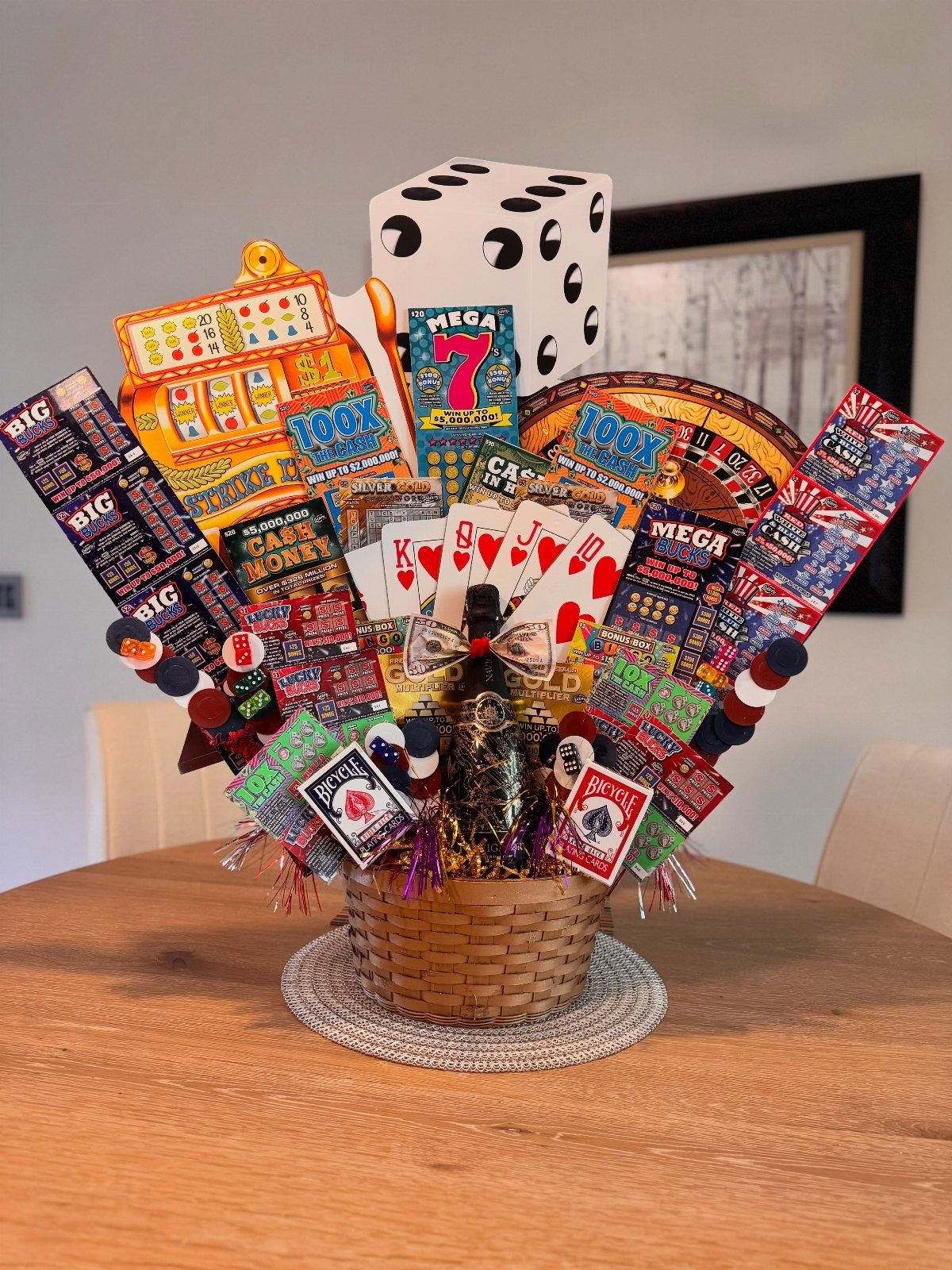 Casino themed raffle basket with playing cards, dice, and colorful tickets on table.