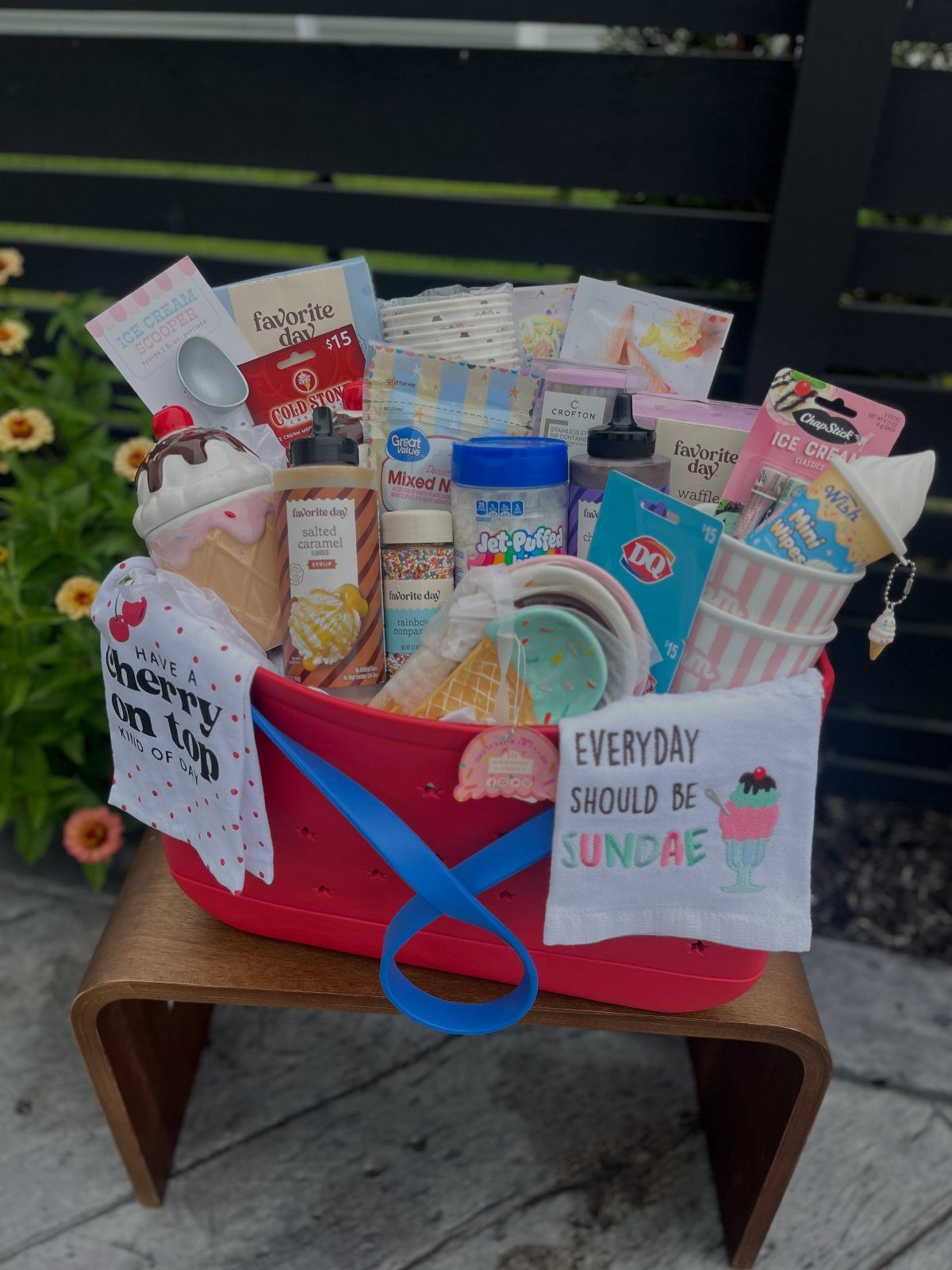 Ice cream themed raffle basket in a red tub with toppings and puns.