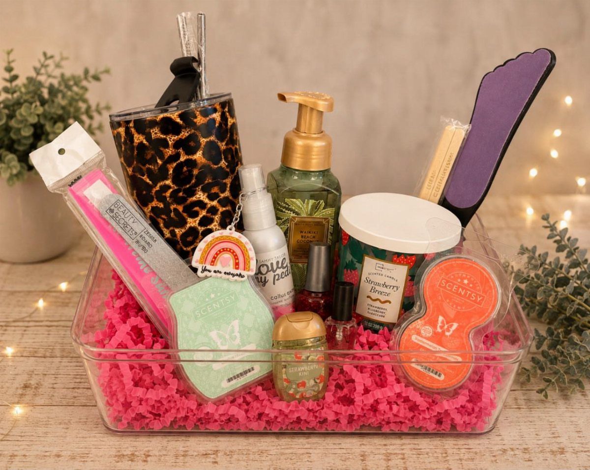 Self-care spa gift basket with beauty products and a tumbler in a plastic bin.