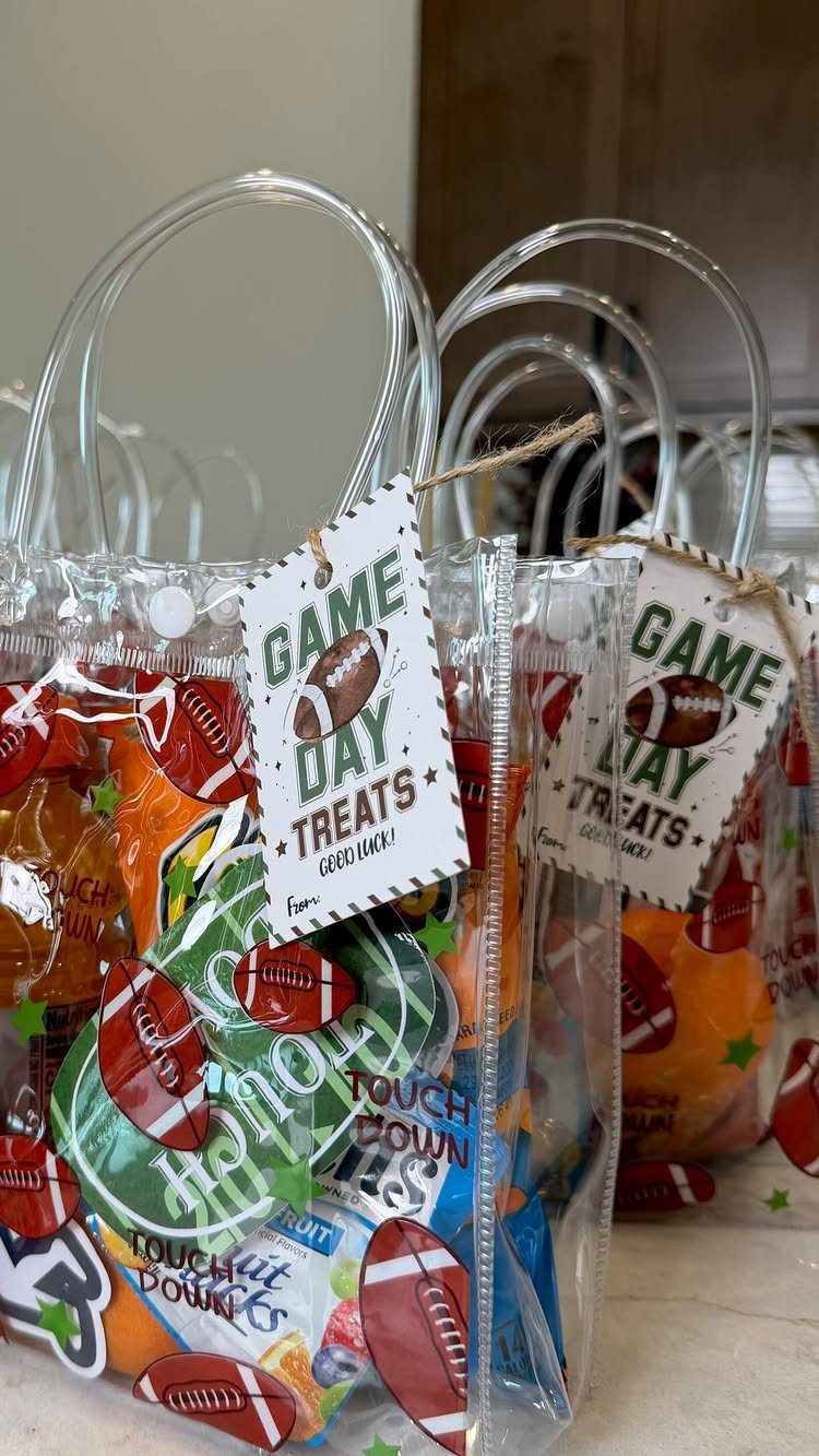 Clear plastic tote bags filled with football-themed snacks and game day treat tags.