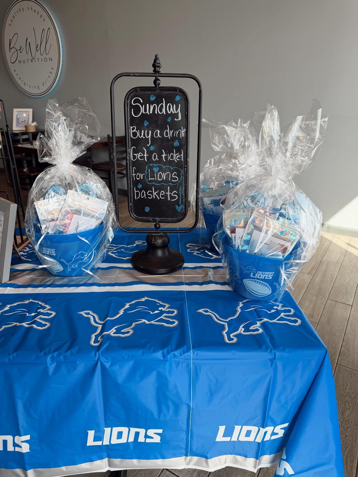 Blue Detroit Lions themed raffle baskets wrapped in cellophane on a matching tablecloth.