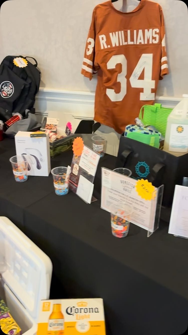 Tailgating raffle prize display featuring an orange football jersey, cooler, and beer box.