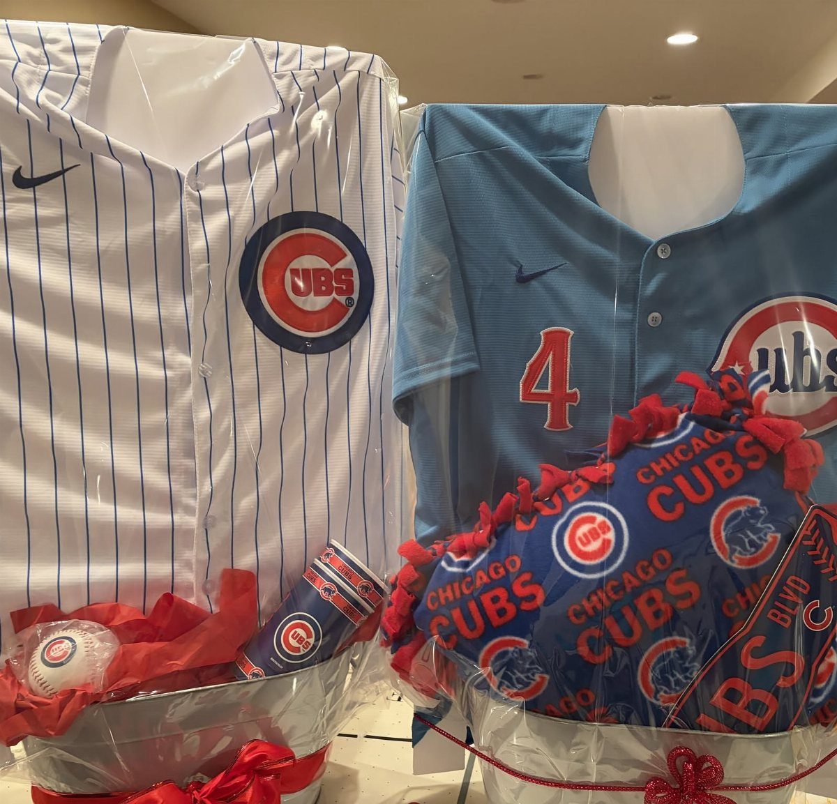 Chicago Cubs themed raffle baskets with jerseys, a cap, and a cup.