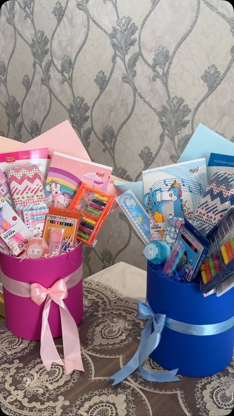 Pink and blue gift baskets filled with colorful school supplies and notebooks.