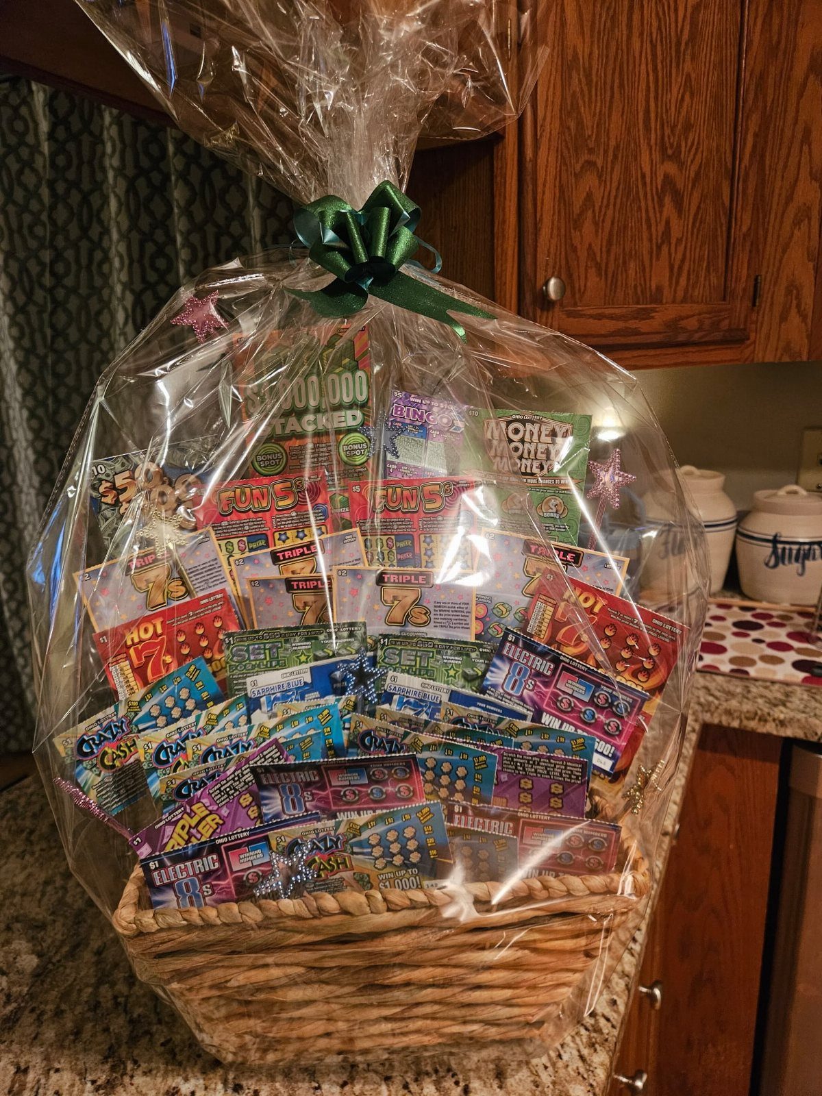 Wicker basket filled with colorful lottery tickets wrapped in clear cellophane with green ribbon.