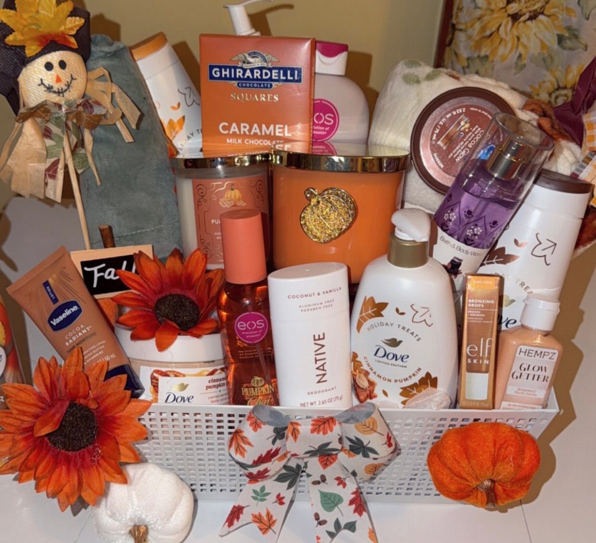 Autumn themed gift basket with skincare products, chocolates, and fall decorations.