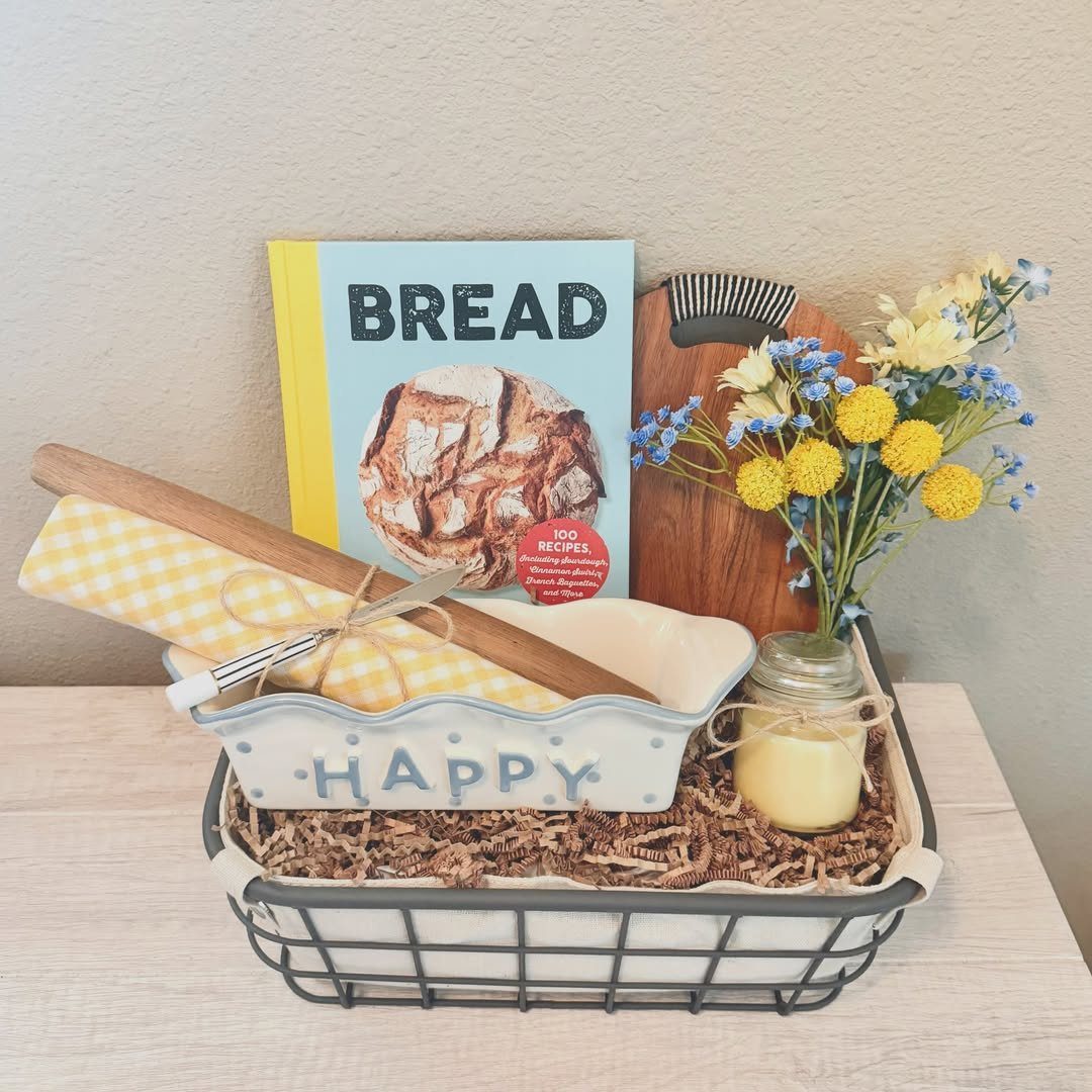 Baking gift basket with bread cookbook, rolling pin, and yellow flowers in a wire basket