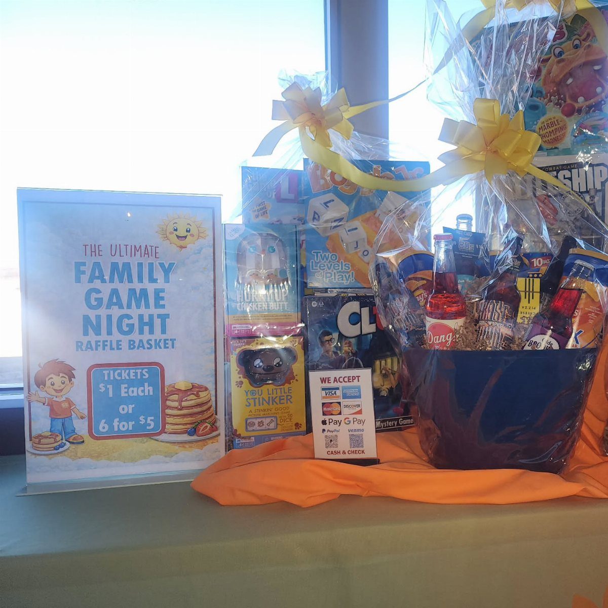 Blue gift basket filled with board games and snacks for a family game night.