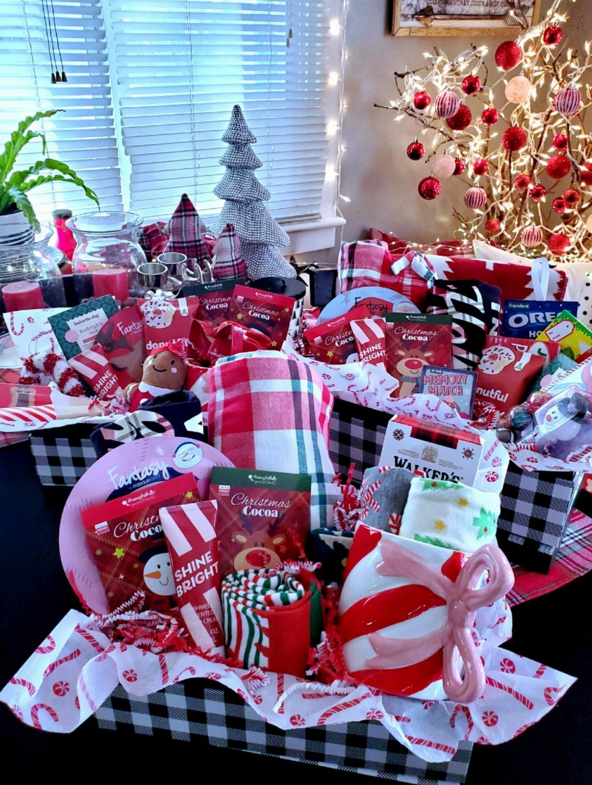 Hot cocoa gift basket with red and white treats in a checkered bin.