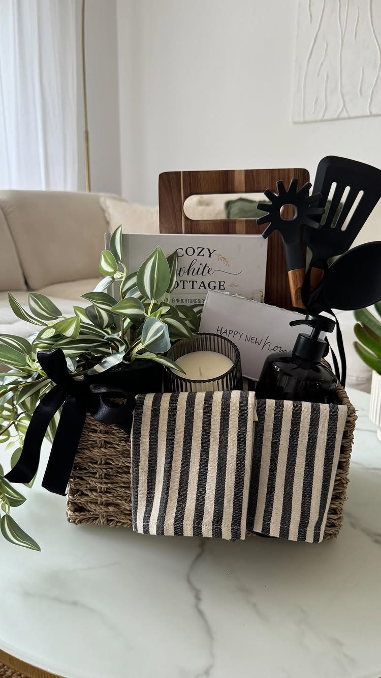 Housewarming gift basket with a plant, candle, kitchen tools, and a welcome card.