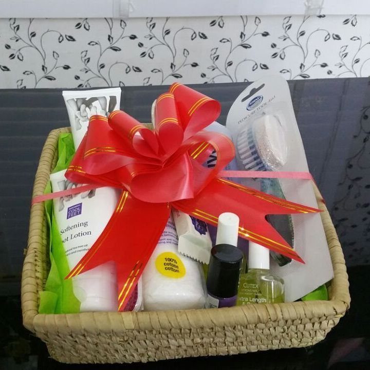 Pedicure gift basket with nail polish, foot lotion, and scrub brush with red bow.