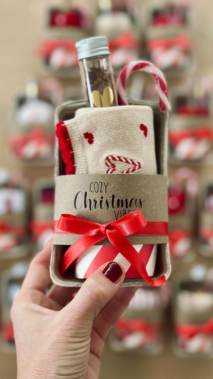 Small Christmas gift basket with cozy socks, candy cane, and striped mug.